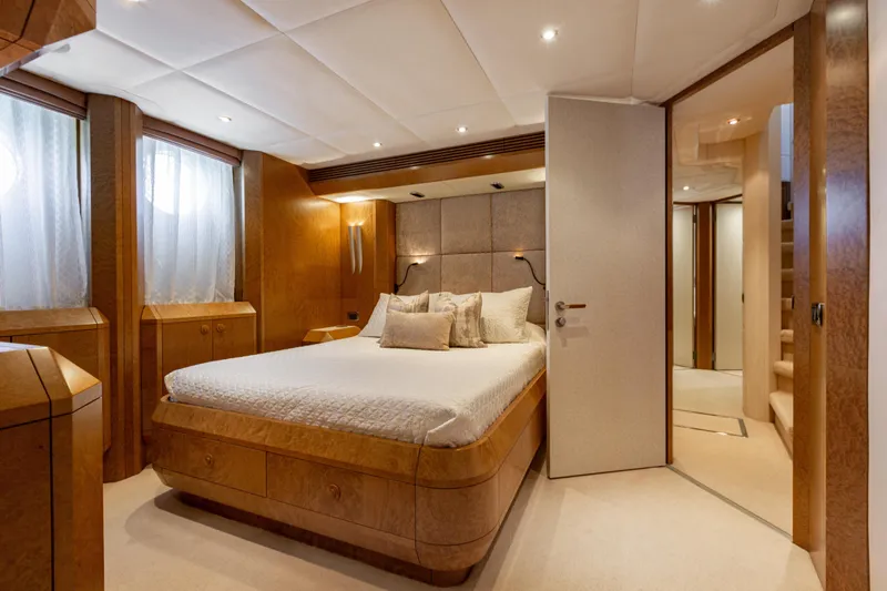 Benita Blue Yacht Photos Pics Luxurious bedroom interior on 2005 Evolution Yachts Custom, featuring elegant wood paneling and plush bedding.