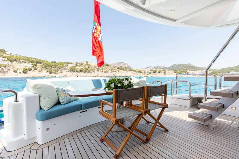 Benita Blue Yacht Photos Pics Luxurious 2005 Evolution Yachts Custom deck with seating, ocean view, and vibrant red flag.