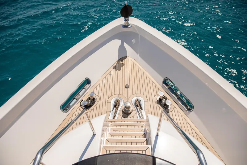 Benita Blue Yacht Photos Pics Bow view of 2005 Evolution Yachts Custom, featuring teak deck and ocean backdrop.