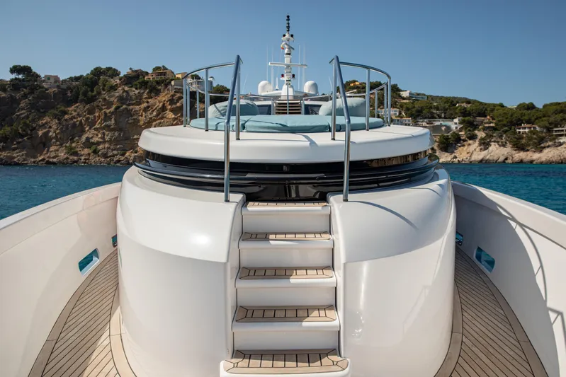 Benita Blue Yacht Photos Pics Luxurious 2005 Evolution Yachts Custom yacht deck with elegant stairs and scenic coastal backdrop.