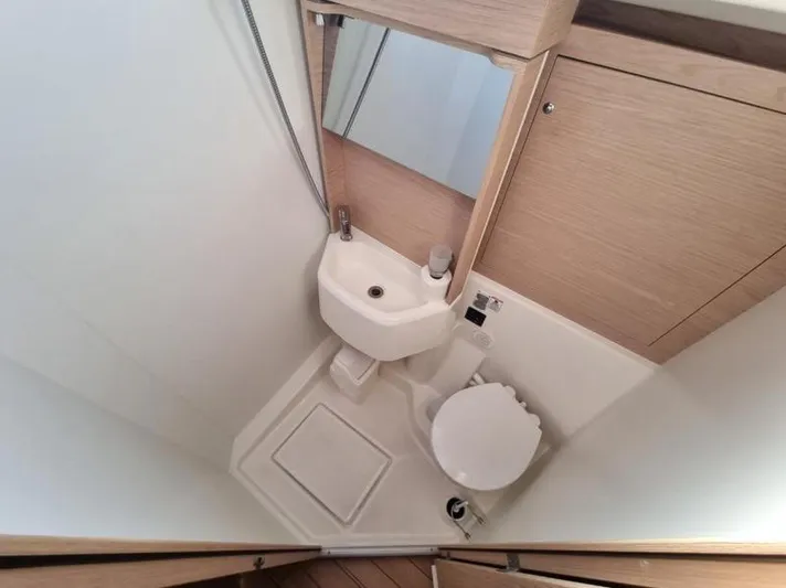 Miss Alice Yacht Photos Pics Compact bathroom in a 2018 Beneteau 51.1 yacht, featuring a toilet, sink, and mirror.