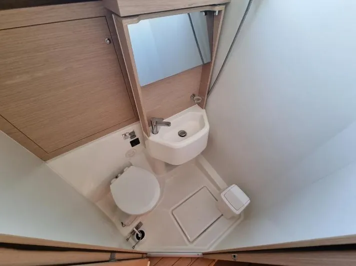 Miss Alice Yacht Photos Pics Compact bathroom in 2018 Beneteau 51.1 yacht with sink, toilet, and mirror.