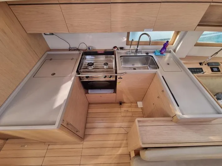 Miss Alice Yacht Photos Pics Modern kitchen in a 2018 Beneteau 51.1 yacht with wood finish and stainless steel appliances.