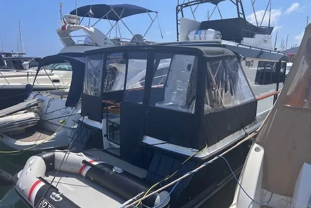  Yacht Photos Pics 2022 Targa 37 boat docked at marina, featuring enclosed cabin and inflatable dinghy.