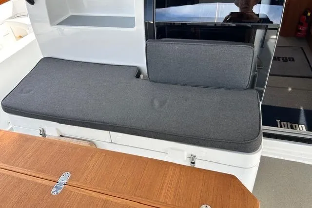  Yacht Photos Pics Interior seating area of a 2022 Targa 37 boat with gray cushions and wooden table.