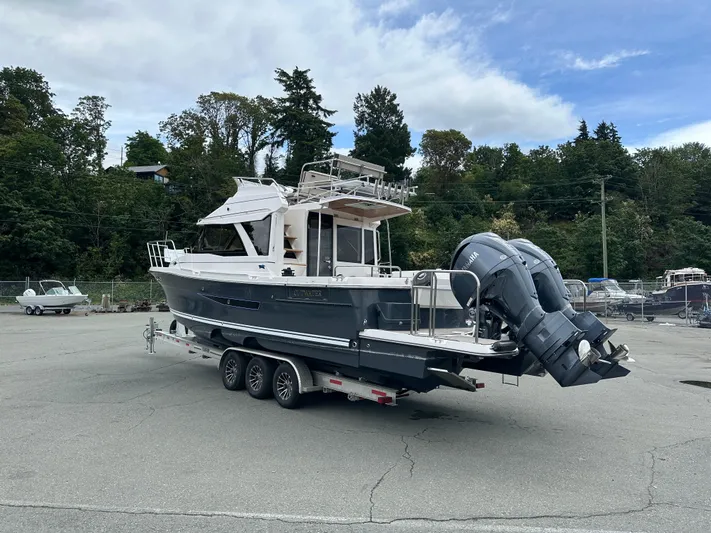  Yacht Photos Pics 2025 Cutwater C-32 CB boat on trailer, parked outdoors with trees in background.