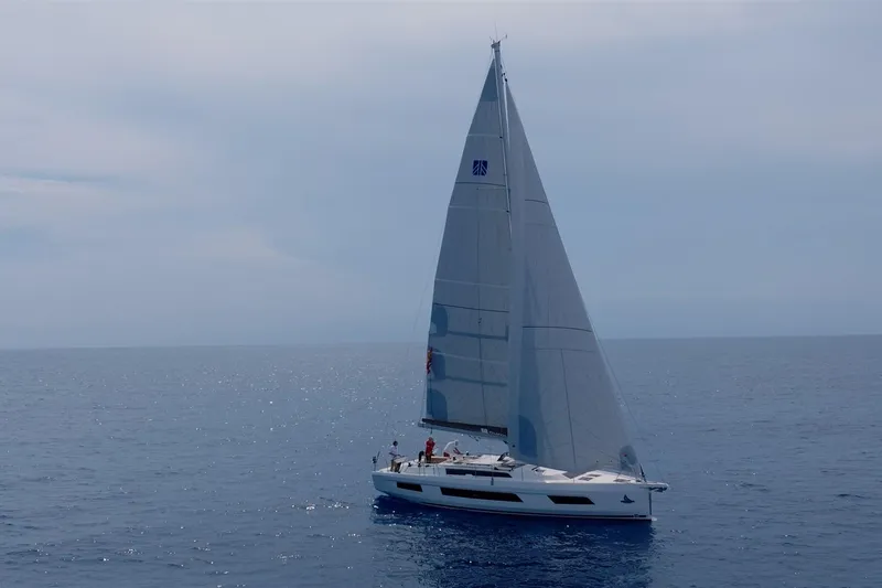  Yacht Photos Pics 2024 Dufour 44 sailboat cruising on open sea under clear skies.
