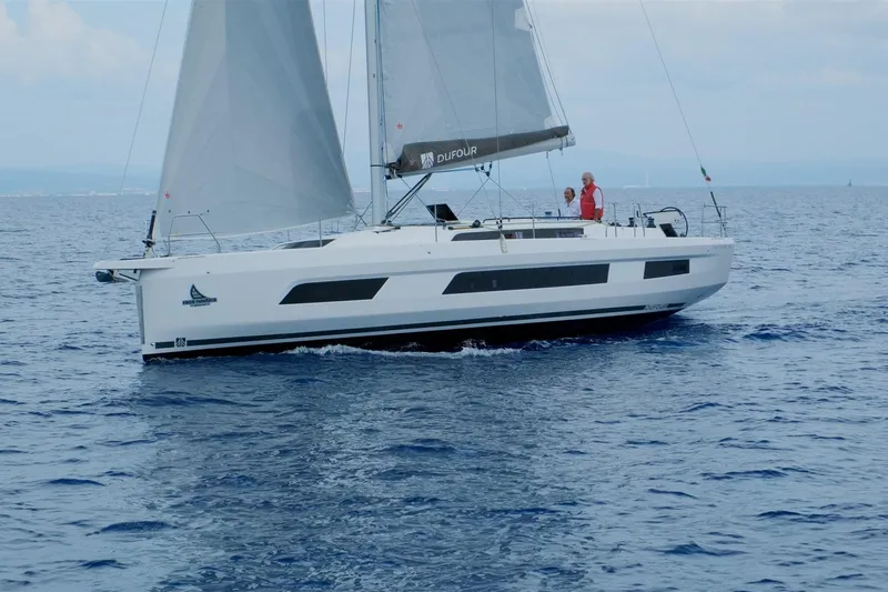  Yacht Photos Pics 2024 Dufour 44 sailboat cruising on open water with sails unfurled.
