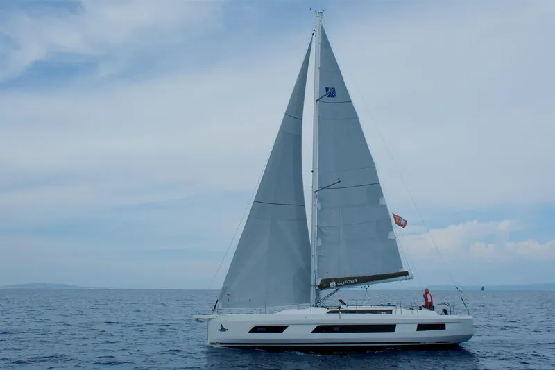  Yacht Photos Pics 2024 Dufour 44 sailboat on open sea under clear sky.