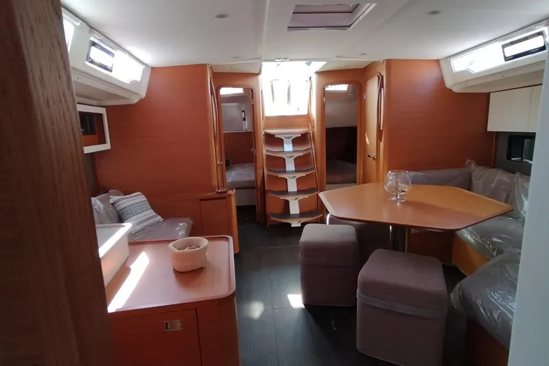  Yacht Photos Pics 2024 Dufour 44 yacht interior with modern wood finish and cozy seating area.