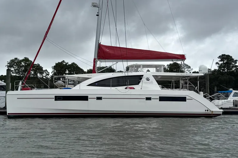  Yacht Photos Pics 2014 Leopard 48 catamaran with red sail, docked on a cloudy day.
