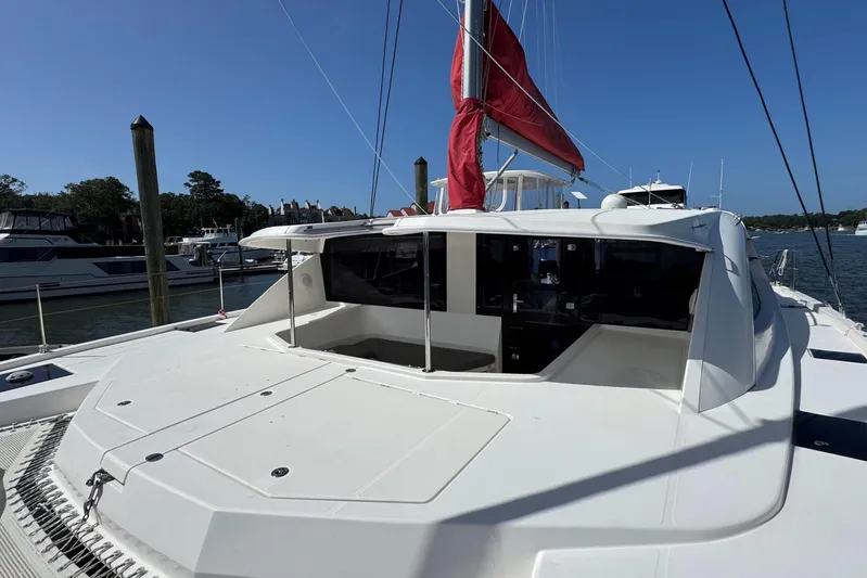  Yacht Photos Pics 2014 Leopard 48 yacht with red sail, docked in a marina under clear blue sky.