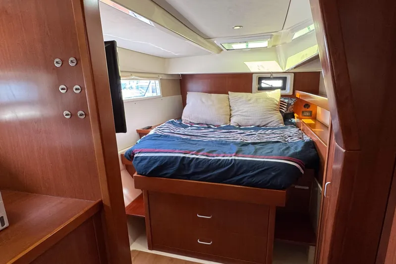 Yacht Photos Pics Luxurious cabin interior of 2014 Leopard 48 yacht with cozy bed and wooden furnishings.