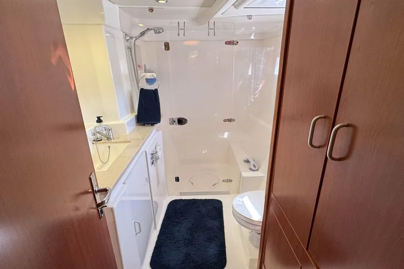  Yacht Photos Pics Luxurious bathroom in 2014 Leopard 48 yacht with shower, sink, and wooden cabinetry.