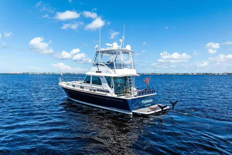 Highlander Yacht Photos Pics 2019 Sabre Flybridge yacht on open water under a clear blue sky.