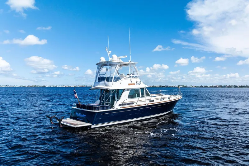 Highlander Yacht Photos Pics 2019 Sabre Flybridge yacht cruising on open water under a clear blue sky.