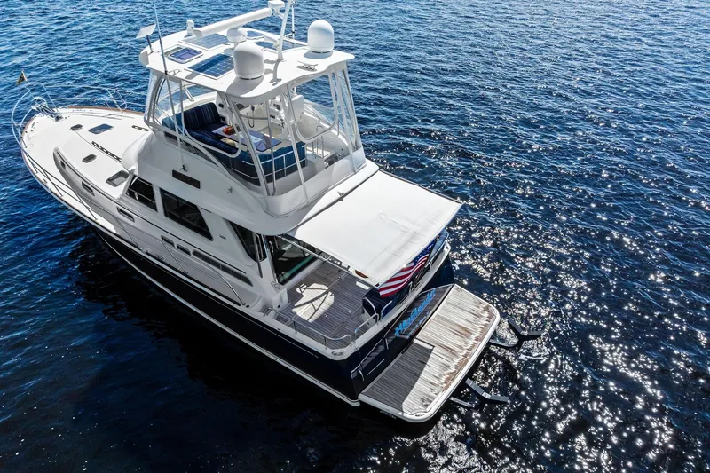 Highlander Yacht Photos Pics 2019 Sabre Flybridge yacht on sparkling blue water, aerial view.