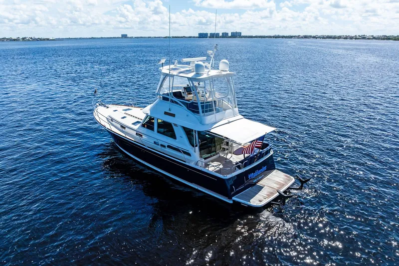Highlander Yacht Photos Pics 2019 Sabre Flybridge yacht cruising on open water under a clear sky.