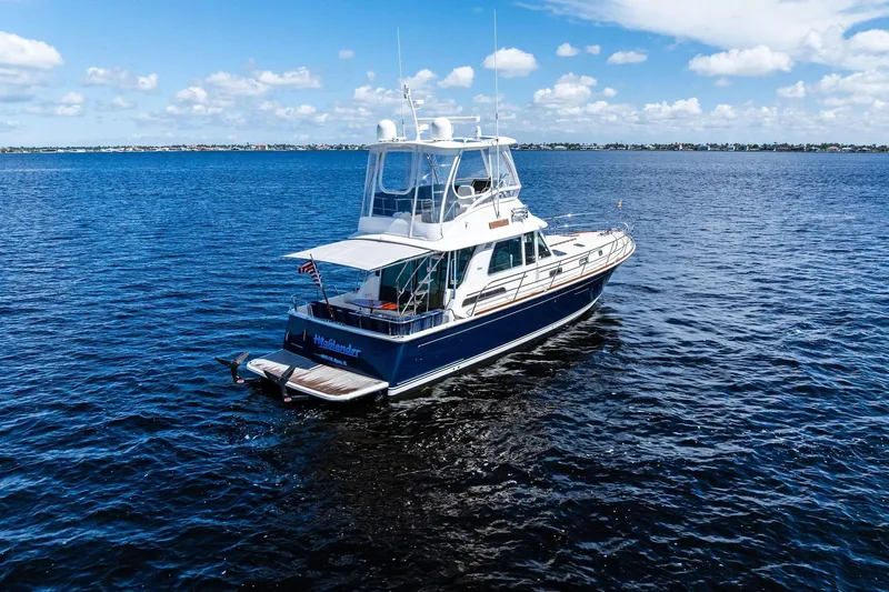 Highlander Yacht Photos Pics 2019 Sabre Flybridge yacht cruising on open water under a clear blue sky.