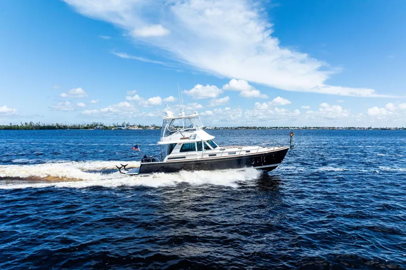Highlander Yacht Photos Pics 2019 Sabre Flybridge cruising on open water under a clear blue sky.