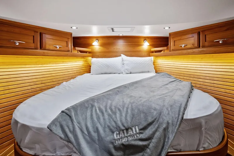 Highlander Yacht Photos Pics Luxurious 2019 Sabre Flybridge yacht cabin with cozy bed and elegant wood paneling.