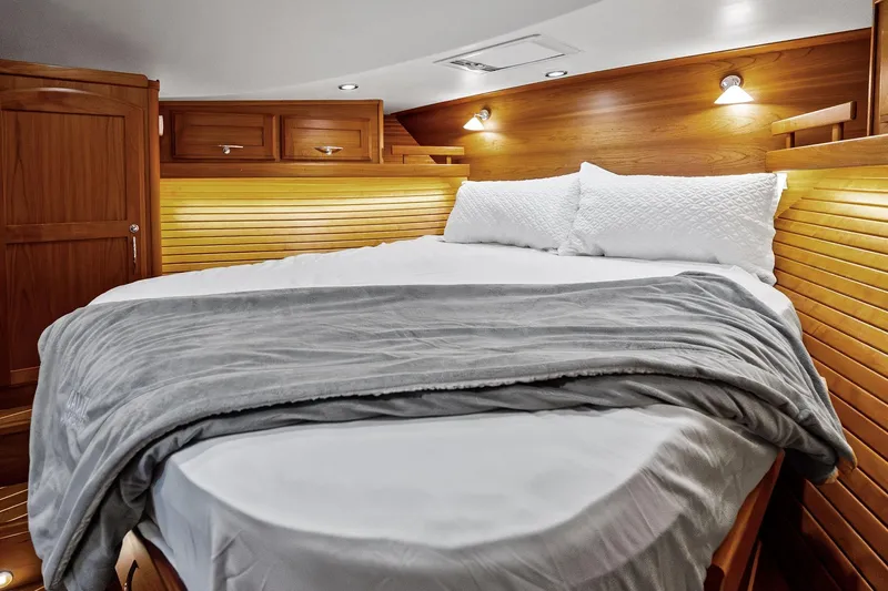 Highlander Yacht Photos Pics Luxurious 2019 Sabre Flybridge cabin interior with cozy bed and wooden accents.