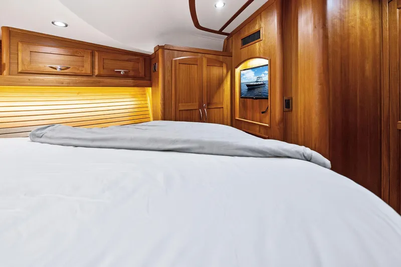 Highlander Yacht Photos Pics Luxurious 2019 Sabre Flybridge yacht cabin with wooden interior and cozy bedding.