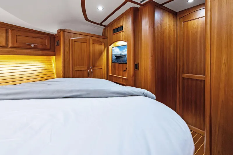 Highlander Yacht Photos Pics Luxurious 2019 Sabre Flybridge yacht cabin with wooden interior and cozy bedding.