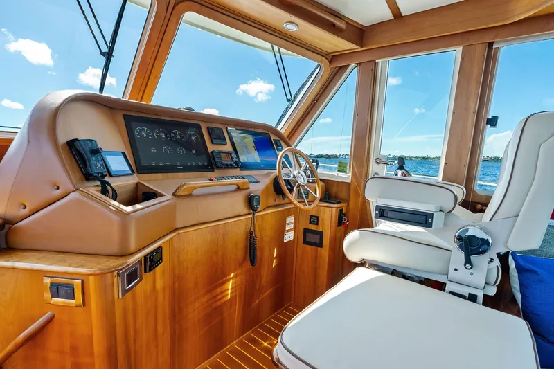 Highlander Yacht Photos Pics 2019 Sabre Flybridge helm with wooden dashboard, modern controls, and ocean view.