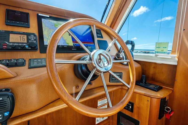 Highlander Yacht Photos Pics 2019 Sabre Flybridge helm with wooden steering wheel and navigation instruments.