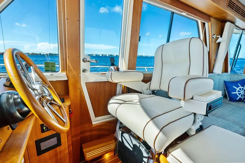 Highlander Yacht Photos Pics Luxurious interior of 2019 Sabre Flybridge yacht with captain's chair and steering wheel.
