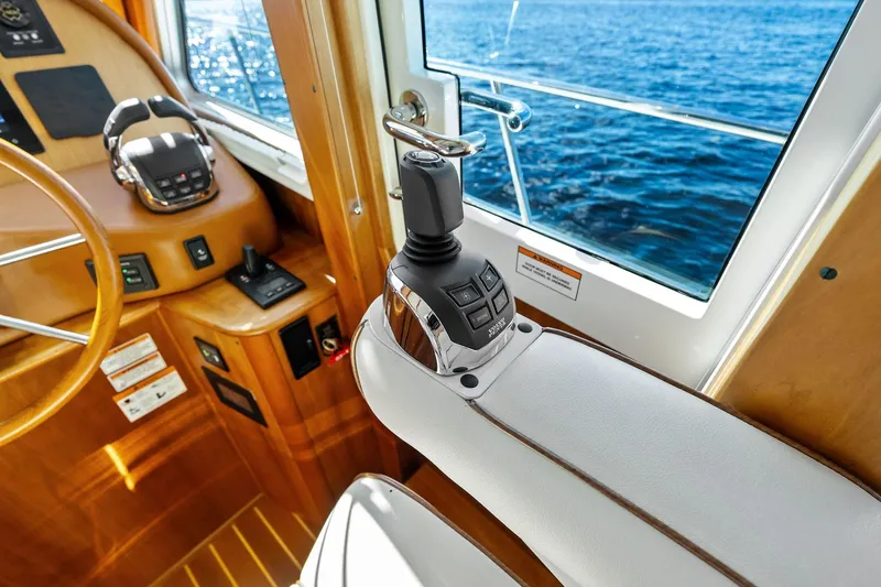 Highlander Yacht Photos Pics 2019 Sabre Flybridge helm with joystick control, overlooking ocean through window.