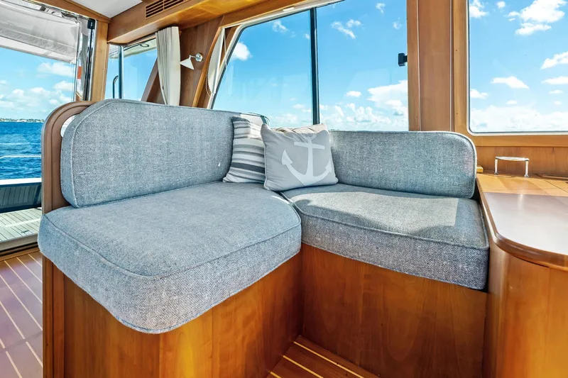 Highlander Yacht Photos Pics 2019 Sabre Flybridge interior with cozy seating, nautical-themed cushions, and ocean view.
