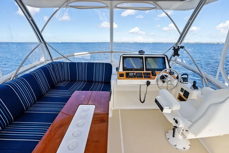 Highlander Yacht Photos Pics 2019 Sabre Flybridge yacht interior with blue seating, wooden table, and navigation controls.