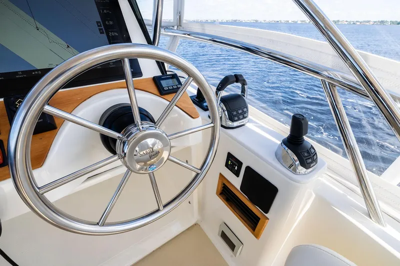 Highlander Yacht Photos Pics 2019 Sabre Flybridge helm with steering wheel and controls, overlooking the ocean.