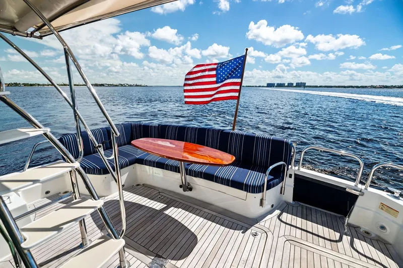 Highlander Yacht Photos Pics 2019 Sabre Flybridge yacht deck with seating, American flag, and ocean view.