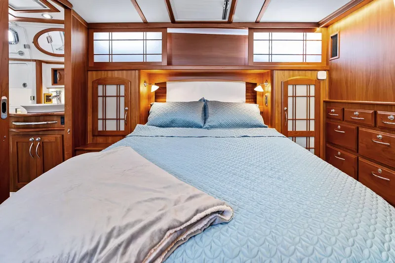 Highlander Yacht Photos Pics Luxurious 2019 Sabre Flybridge yacht bedroom with elegant wood finish and cozy bedding.