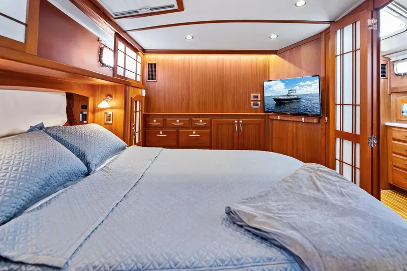 Highlander Yacht Photos Pics Luxurious 2019 Sabre Flybridge yacht bedroom with wood paneling and modern amenities.
