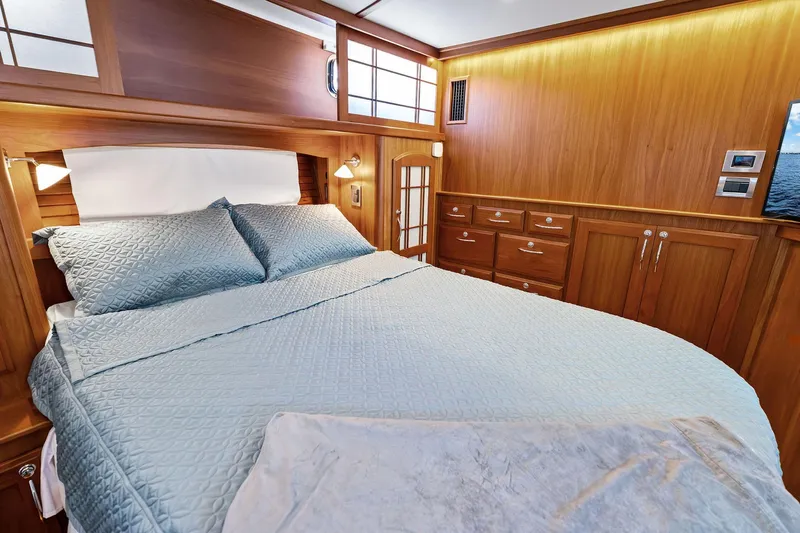 Highlander Yacht Photos Pics Luxurious 2019 Sabre Flybridge cabin with elegant wood paneling and cozy bedding.