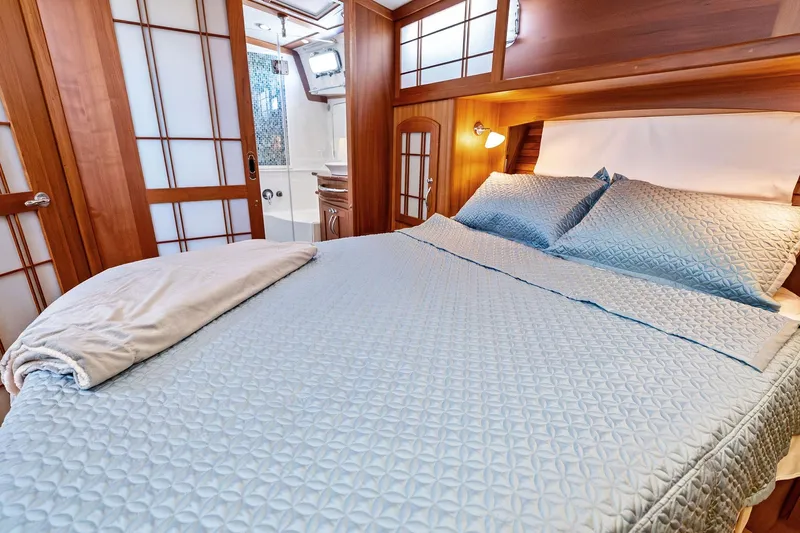 Highlander Yacht Photos Pics Luxurious bedroom interior on 2019 Sabre Flybridge yacht with elegant wood paneling.