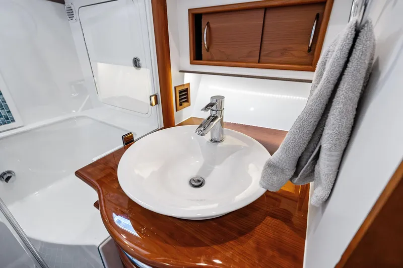 Highlander Yacht Photos Pics Luxurious 2019 Sabre Flybridge bathroom with elegant sink and wooden cabinetry.