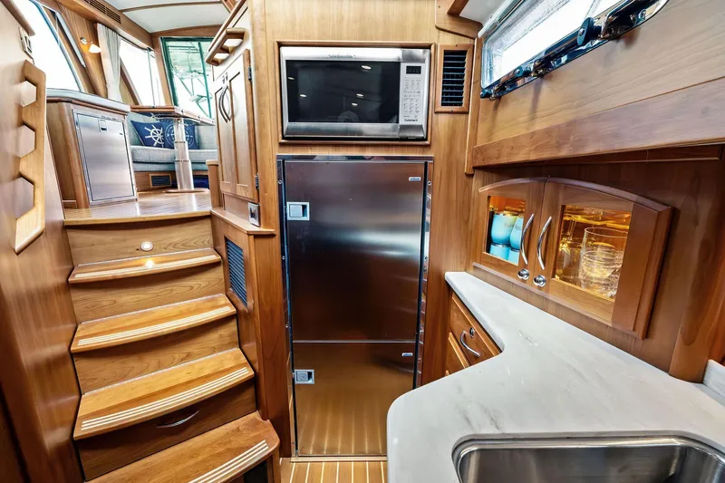 Highlander Yacht Photos Pics Luxurious 2019 Sabre Flybridge yacht interior with wooden cabinetry and modern kitchen amenities.