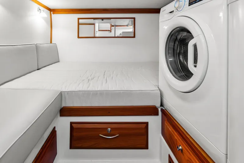 Highlander Yacht Photos Pics 2019 Sabre Flybridge interior with bed, washing machine, and wooden drawers.