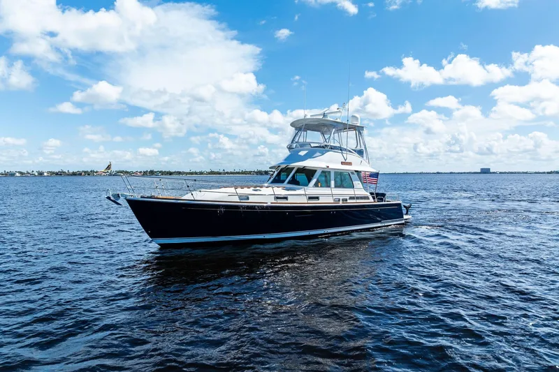 Highlander Yacht Photos Pics 2019 Sabre Flybridge yacht cruising on open water under a clear blue sky.
