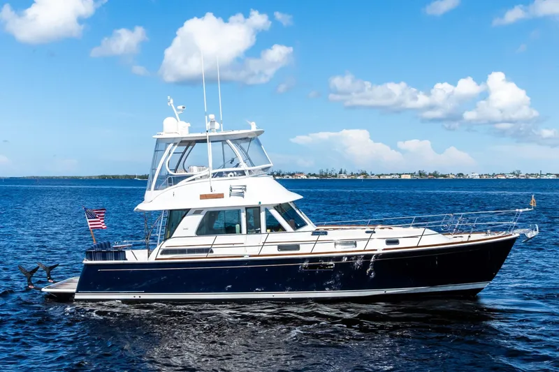 Highlander Yacht Photos Pics 2019 Sabre Flybridge yacht cruising on a sunny day with blue skies and calm waters.