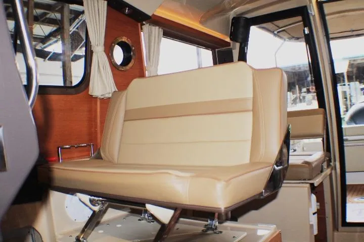 Knot Working Yacht Photos Pics Interior of 2020 Ranger Tugs R-27 boat with beige seating and wooden accents.