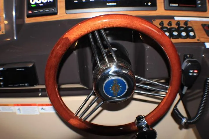 Knot Working Yacht Photos Pics Steering wheel of 2020 Ranger Tugs R-27 boat, featuring wood finish and control panel.