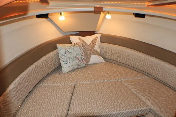 Knot Working Yacht Photos Pics 2020 Ranger Tugs R-27 cabin interior with cozy seating and decorative pillows.