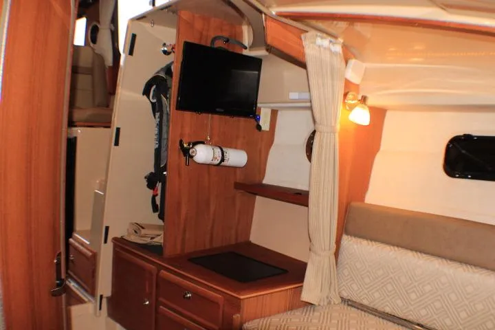 Knot Working Yacht Photos Pics 2020 Ranger Tugs R-27 cabin interior with TV, storage, and seating area.