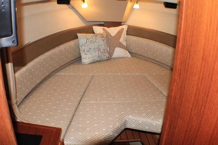 Knot Working Yacht Photos Pics 2020 Ranger Tugs R-27 cabin interior with cozy bed and decorative pillows.
